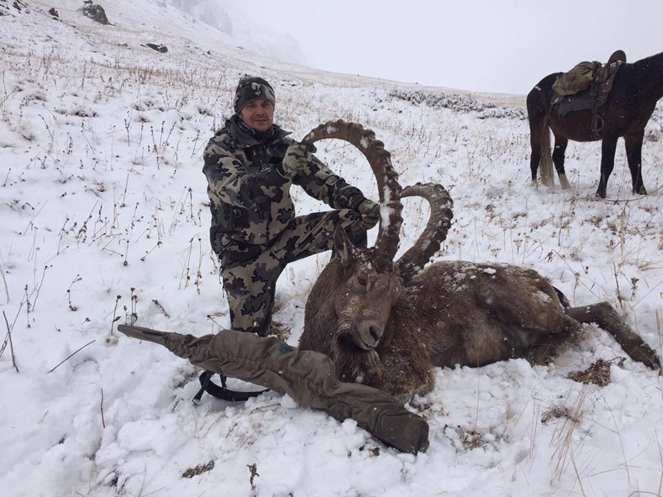 Hunter taking picture with his hunted ibex in Kyrgyzstan, example of successful client of Teron who went ibex hunting in Kyrgyzstan
